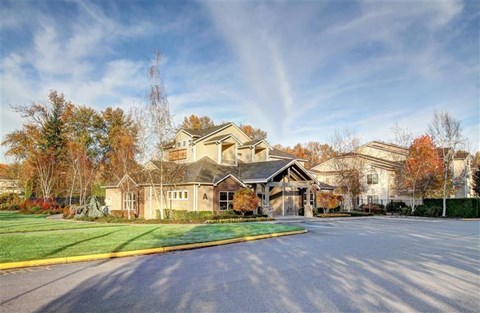 A large, well-maintained building with a spacious driveway in front.