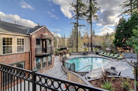 A backyard with a pool and patio furniture.