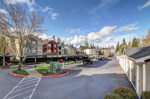 A parking lot with a red circle in the middle and a building in the background.