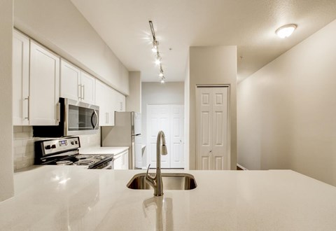 A kitchen with white cabinets and a white countertop.
