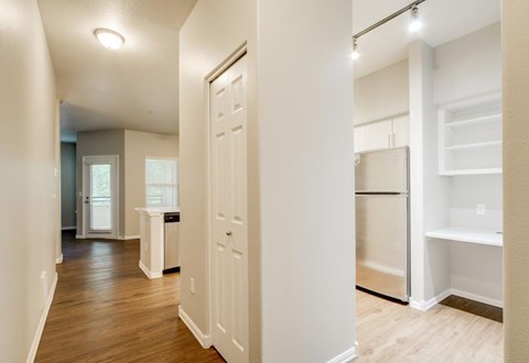 A kitchen with white cabinets and a refrigerator.