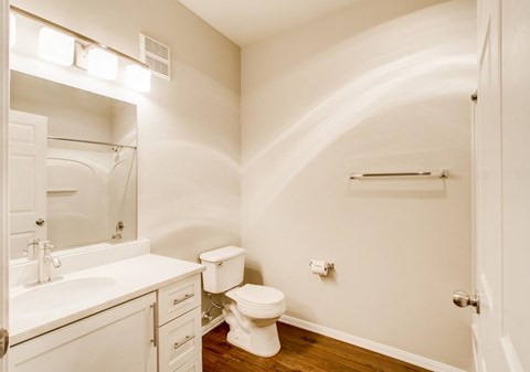 A white bathroom with a toilet, sink, and mirror.