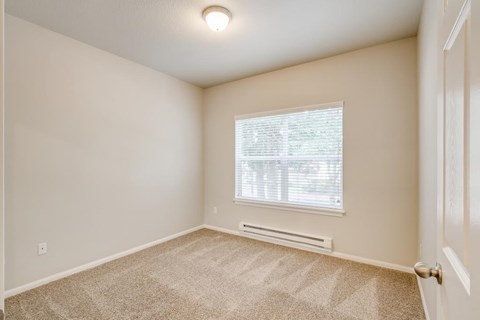 A room with a window and carpeted floor.