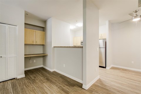 A kitchen area with a refrigerator, cabinets, and a countertop.