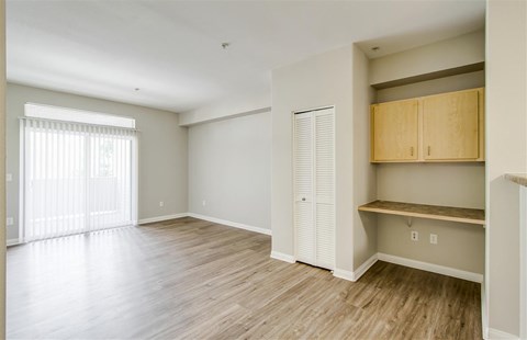 A room with wooden flooring and a window with blinds.