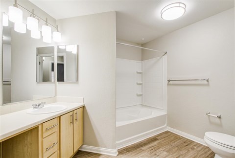 A white bathroom with a sink, toilet, and bathtub.