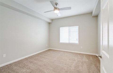 A room with a ceiling fan and a window.