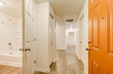 A hallway with white doors and a wooden floor.