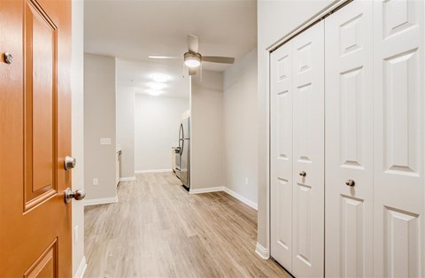 A hallway with a wooden floor and white walls.