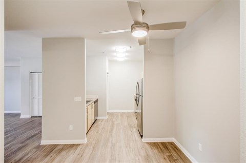 A room with a ceiling fan and a wooden floor.