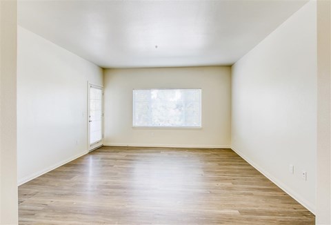 Empty room with wooden floor and a window.
