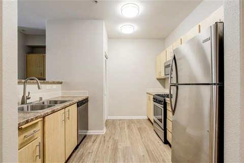 A kitchen with a refrigerator, sink, and oven.