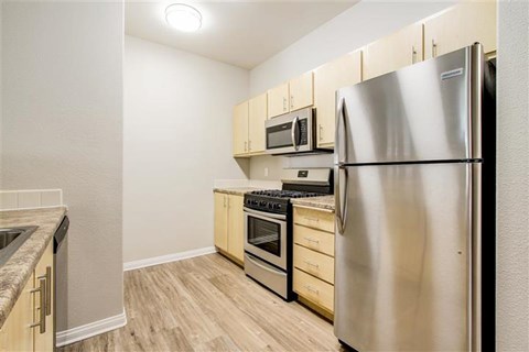 A kitchen with a stainless steel refrigerator, oven, and microwave.