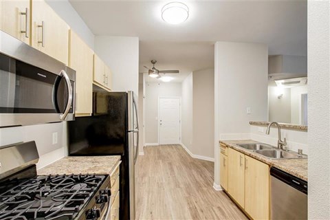 A kitchen with a black stove top oven and a black refrigerator.
