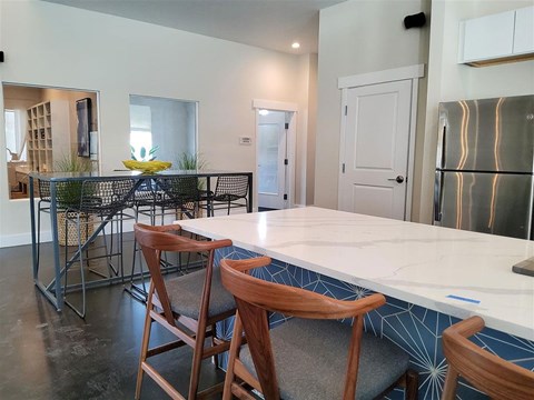 A kitchen with a table and chairs in the foreground.