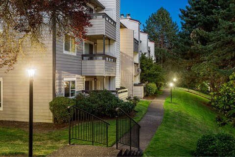 A residential building with a black gate and a sidewalk.