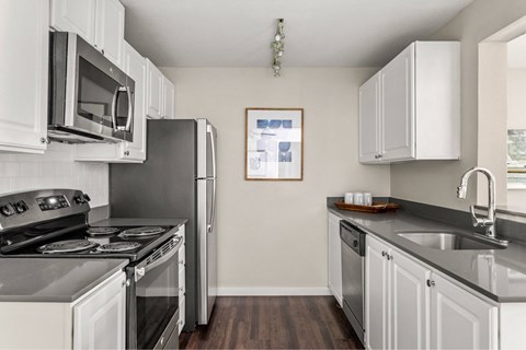 A kitchen with white cabinets and a black stove top oven.