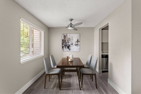A dining room with a wooden table and chairs.