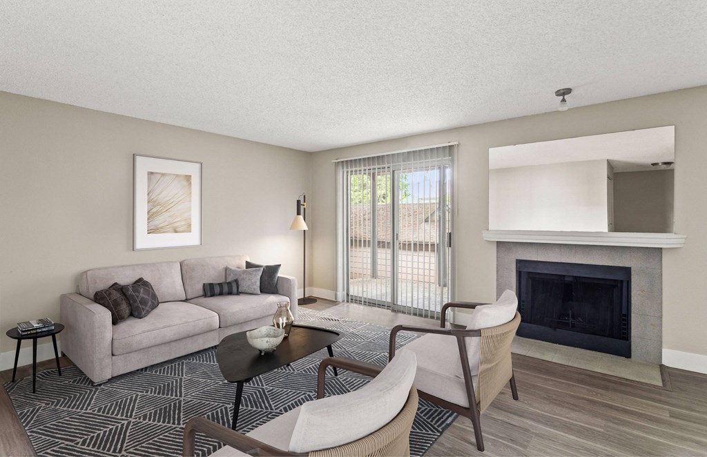 A living room with a grey couch, a black coffee table, and a fireplace.