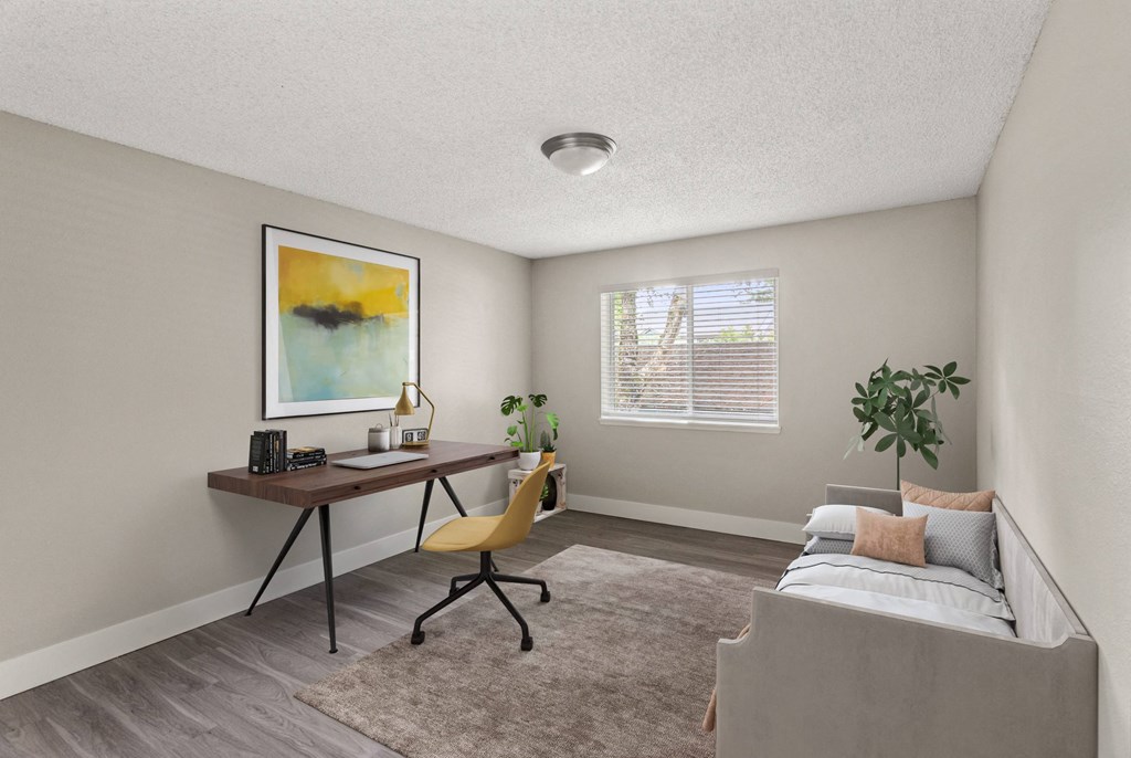 A room with a bed, desk, and chair.