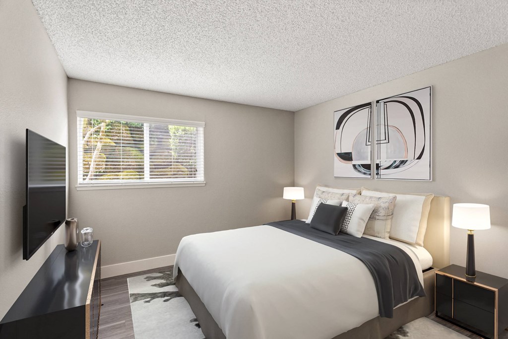 A bedroom with a large bed and a television on the wall.