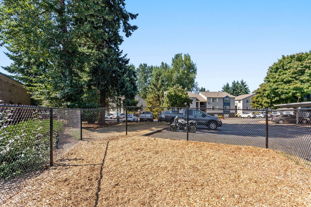 A parking lot with cars and a fence.