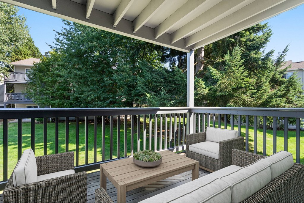 A patio with a table and chairs under a roof.