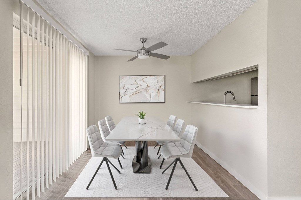 A dining room with a white table and chairs.