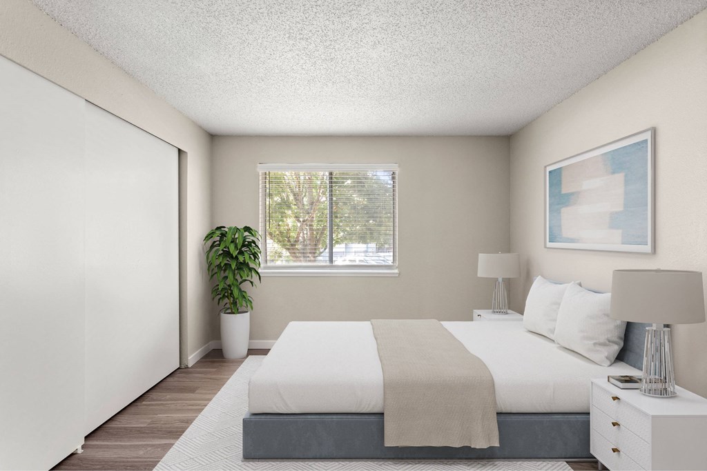 A bedroom with a large bed and a potted plant.