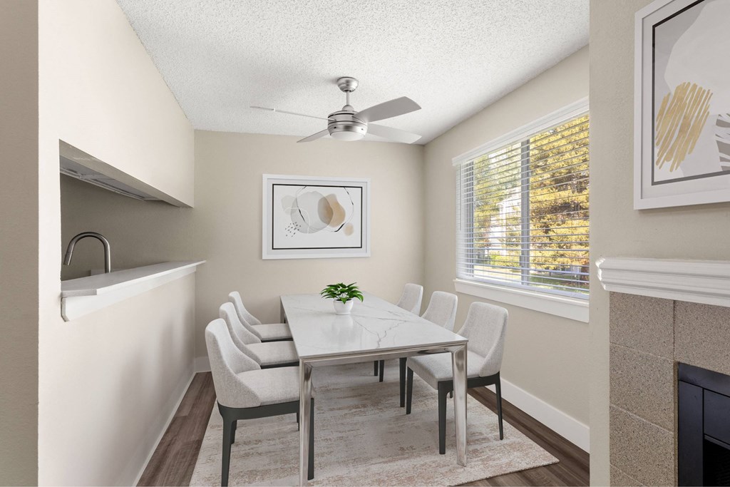 A dining room with a white table and chairs.