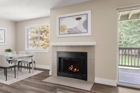 A living room with a fireplace and a painting above it.