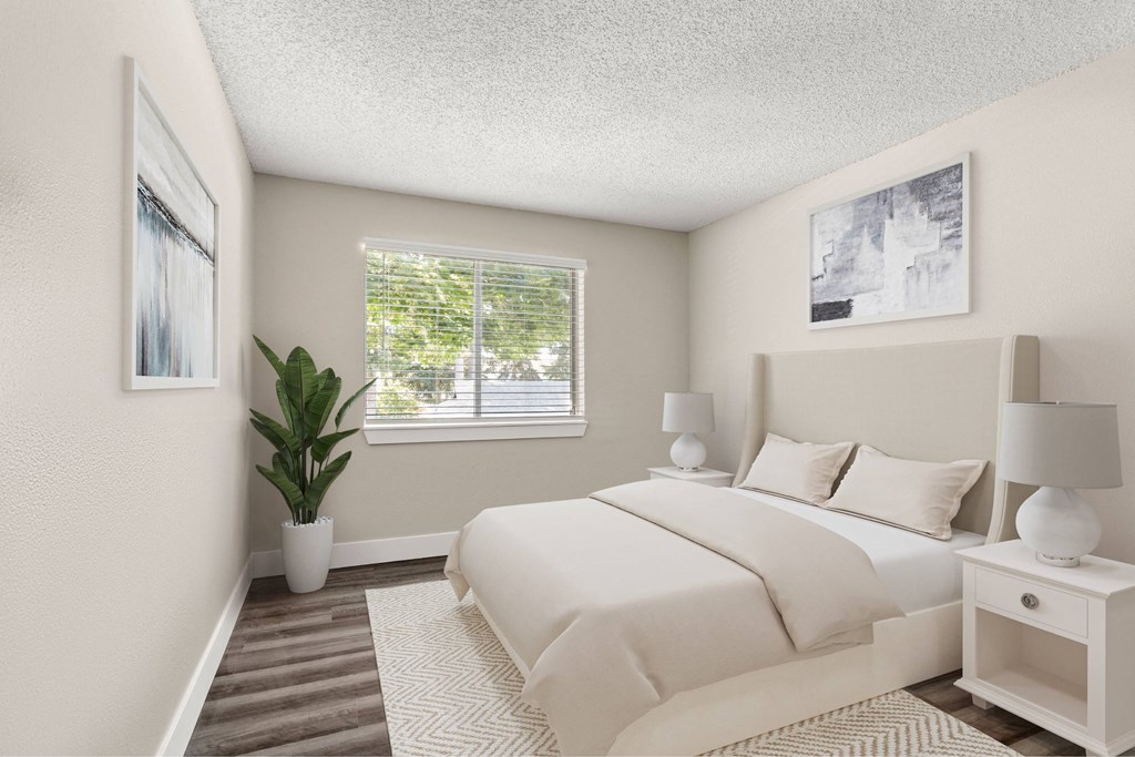 A bedroom with a large bed, two lamps, and a potted plant.