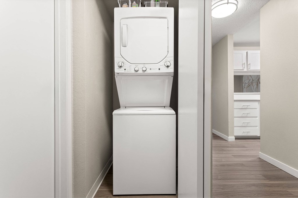 A white washing machine in a narrow hallway.