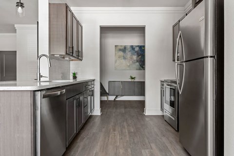 A modern kitchen with stainless steel appliances and wooden cabinets.