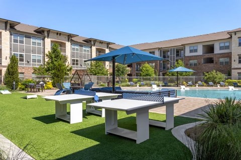A poolside area with tables and umbrellas.