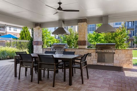 A patio with a table and chairs and a fireplace.