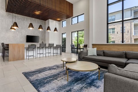 A modern living room with a wooden ceiling and a large window.
