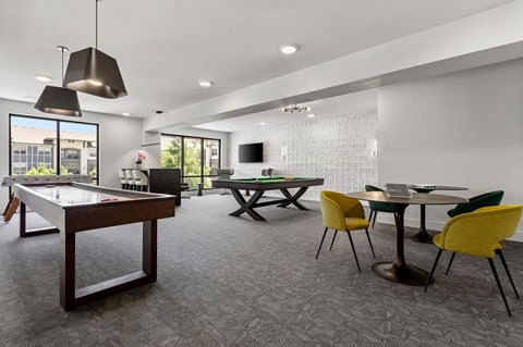 A room with a pool table, ping pong table, and a TV.