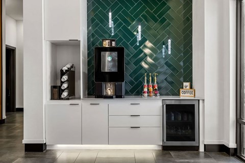 A coffee machine is on a counter with a sign that says coffee.