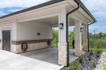 A white garage with a black roof and a stone pillar.