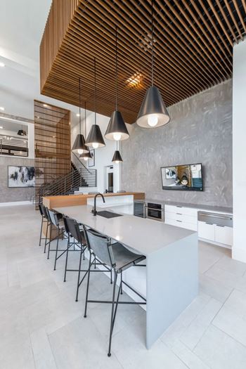 A modern kitchen with a long island and chairs.