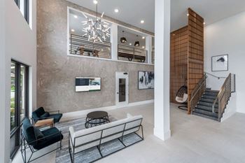 A modern living room with a staircase on the right side.