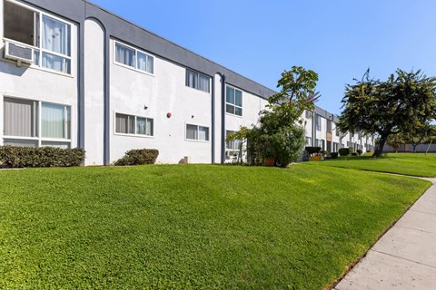 A row of modern apartment buildings with green lawns in front.
