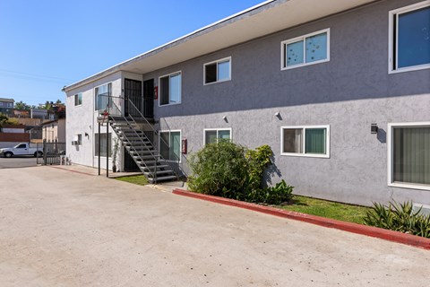 A grey building with a red line on the sidewalk.