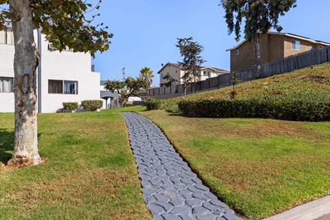 A long grey stone path leads through a grassy area.