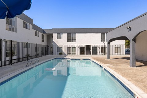 A swimming pool is located in the middle of a courtyard.