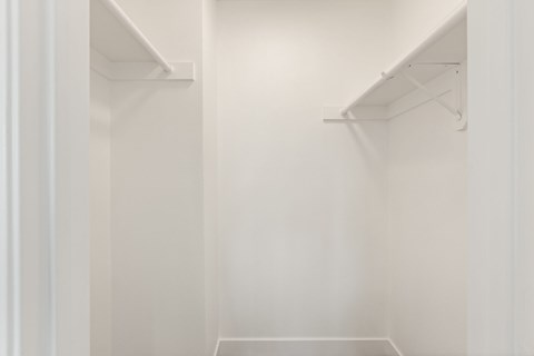 A white closet with two shelves.