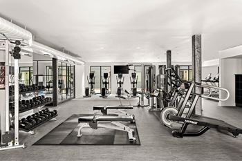 A black and white photo of a gym with a variety of equipment.