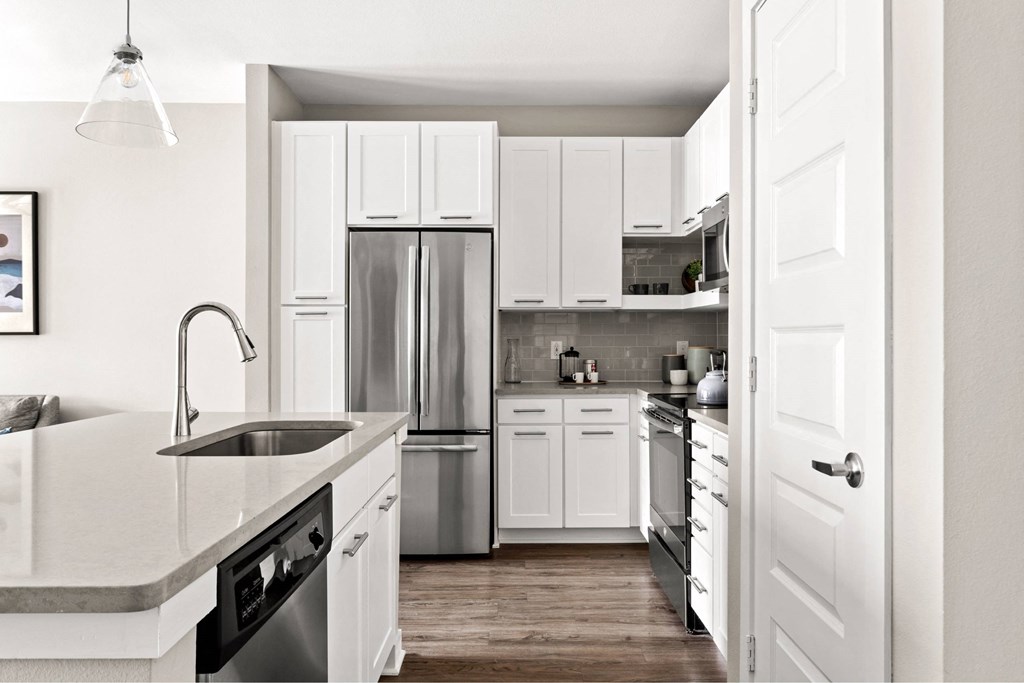 A kitchen with white cabinets and appliances.