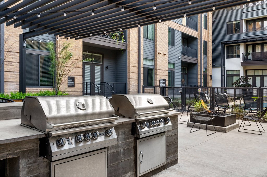 A modern outdoor kitchen with a grill and a table.